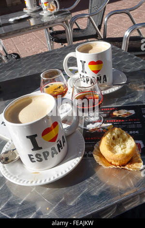Zwei Kaffeetassen von espana mit einem Glas Brandy, Tia Maria und einem Kuchen Benidorm, Provinz Alicante, Spanien Stockfoto