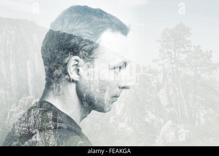Junge Erwachsene kaukasischen Mann, Profilbildnis kombiniert mit Wald Berglandschaft, Doppelbelichtung Fotoeffekt Stockfoto