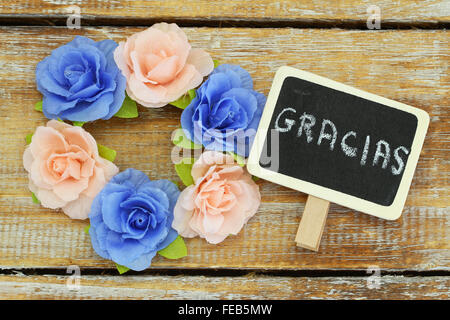 Gracias (Danke in spanischer Sprache) geschrieben am Mini-Tafel mit bunten Rosen Stockfoto