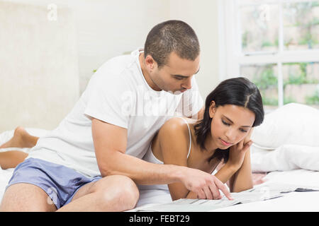 Glückliches Paar im Bett lesen Stockfoto