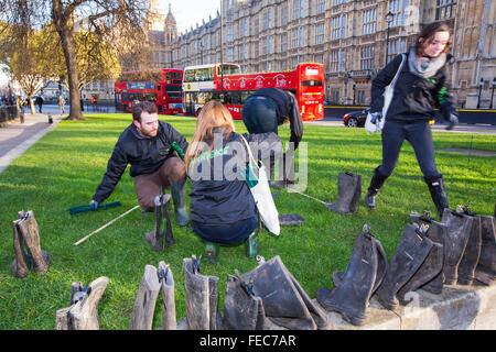 Am Donnerstag, 28. Januar 2016 reichte Greenpeace UK eine Petition zur Downing Street protestieren gegen die jüngsten katastrophalen Überschwemmung. Als Teil des Tages eine Kunst Instalation Gummistiefel wurden außerhalb der Houses of Parliament. Auf jedes Paar Stiefel hing eine Nachricht von jemandem, der von den Überschwemmungen betroffen waren. Hier bereiten die Greenpeace-Mitarbeiter die Instalation. Stockfoto