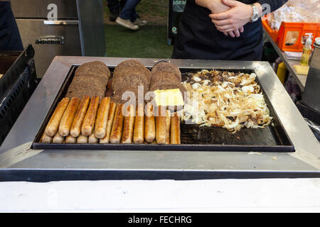 Außerhalb der Gastronomie. Hot Dog Würstchen, Hamburger und Zwiebeln kochen auf einem bratpfanne an einem Fast Food nehmen an Goose Fair, Nottingham, England, UK Abschaltdruck Stockfoto