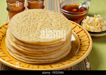 Haufen von traditionellen marokkanischen Beghrir Pfannkuchen mit Honig und Butter serviert Stockfoto