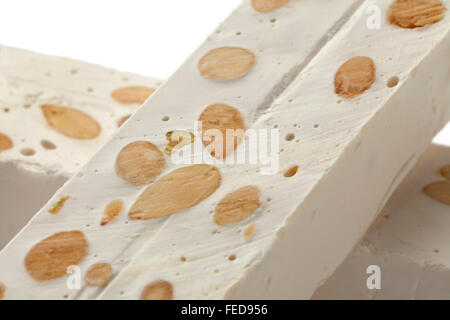 Bars von Nougat mit Mandeln und Pistazien auf weißem Hintergrund Stockfoto