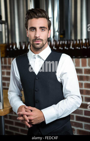 Gut aussehend Barkeeper stützte sich auf Zähler Stockfoto