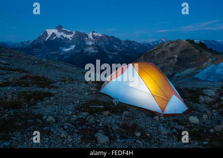 Zelt, beleuchtet von einem Backpacker mit Mt. Shuksan entfernt, Alpenschneehuhn Grat in der Nähe von Mount Baker, Washington State, USA Stockfoto