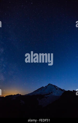 Mount Baker mit Milky Way und unzähligen Sternen und Glühen von Bellingham, angesehen vom Ptarmigan Ridge, Washington State, USA Stockfoto