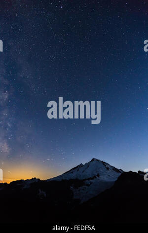 Mount Baker mit Milky Way und unzähligen Sternen und Glühen von Bellingham, angesehen vom Ptarmigan Ridge, Washington State, USA Stockfoto