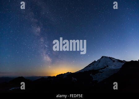 Mount Baker mit Milky Way und unzähligen Sternen und Glühen von Bellingham, angesehen vom Ptarmigan Ridge, Washington State, USA Stockfoto