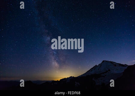 Mount Baker mit Milky Way und unzähligen Sternen und Glühen von Bellingham, angesehen vom Ptarmigan Ridge, Washington State, USA Stockfoto