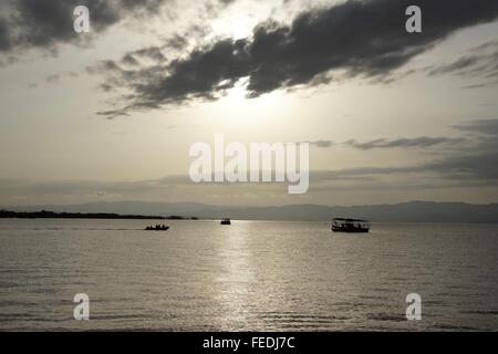 Sonnenaufgang über dem See mit Arbeitsbooten. Stockfoto