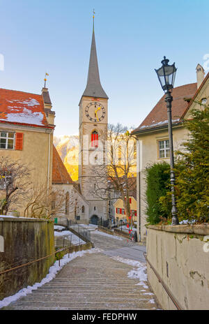 Glockenturm der Kirche von St. Martin bei Sonnenaufgang in Chur. Chur ist die Hauptstadt des Kantons Graubünden in der Schweiz. Es liegt in der alpinen Bündner Rheintal. Die Stadt ist die älteste Stadt der Schweiz Stockfoto