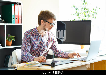 Junge Künstler Zeichnung etwas auf Grafiktablett im home-office Stockfoto