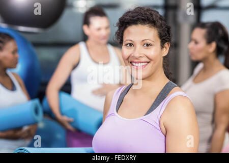 Schwangere Frau mit Trainingsmatte lächelnd Stockfoto