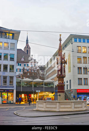 BASEL, Schweiz - 1. Januar 2014: Streetview mit Brunnen in der Altstadt von Basel. Basel ist die drittgrößte Stadt der Schweiz. Es befindet sich auf dem Rhein. Stockfoto