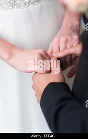 Die Braut und Bräutigam in Brautkleider stehen neben einander und Hand in Hand. Stockfoto