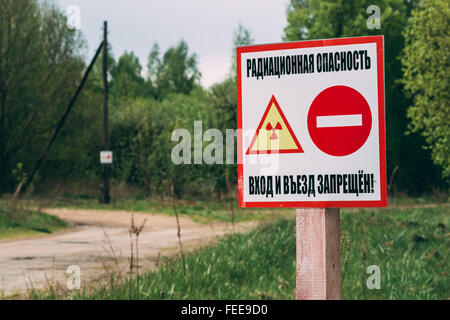 Warnschild ionisierender Strahlung in der Nähe des Dorfes in der Region Gomel, Weißrussland. Strahlungsbereich Kontamination. Stockfoto