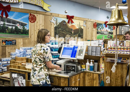 junge Frau Teammitglied in traditionellen Hawaiihemd steht gerade für den nächsten Kunden an Trader Joes Kasse Tucson Stockfoto