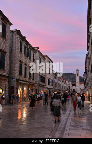 Die Hauptstraße mit Glockenturm in der Ferne wie die Sonne geht über der alten Stadt von Dubrovnik, Kroatien. Stockfoto
