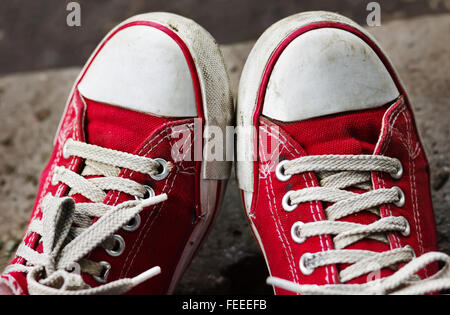 Füße in schmutzige rote Turnschuhe und Jeans im Freien. Ersten Schritt zu machen. Stockfoto
