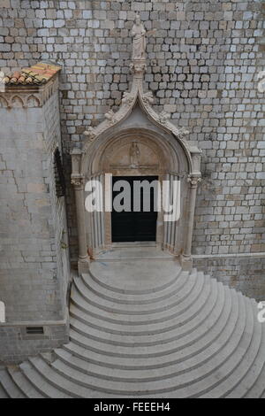Über die geschwungene Treppe an der südlichen Tür des Dominikanerklosters in Dubrovnik steht eine Statue des St. Dominic. Stockfoto