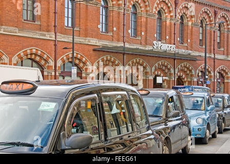 Eine Linie der kultigen schwarzen Londoner Taxis warten außerhalb von St Pancras International Station, für Eurostar und National Rail Services. Stockfoto