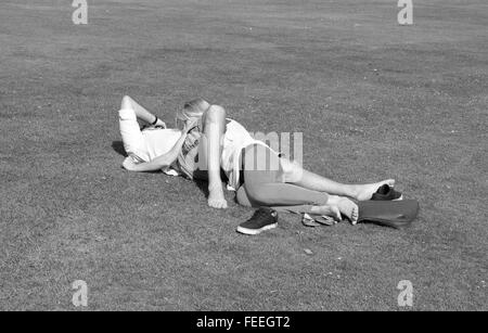 Ineinander verschlungene anonymen Liebhaber auf dem Rasen in einem öffentlichen Park. Juli 2015 Stockfoto