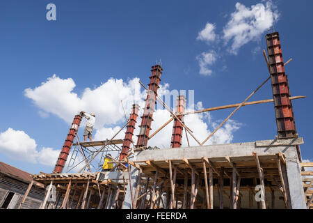 Arbeiter Gießen Zement auf Betonpfeiler Form für den Hausbau auf Baustelle Stockfoto