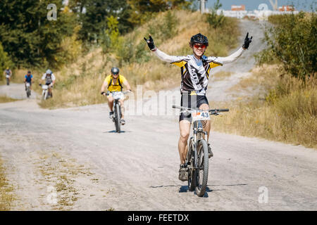 Gruppe Radfahrer auf dem Mountainbike Strecke in sonnigen Tag reiten. Radfahrer mit Handzeichen, Vordergrund. Sport-Wettbewerb, aktiv. Stockfoto