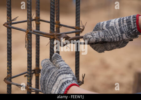 Nahaufnahme von Bau Arbeiter Hände arbeiten mit Zange auf fixin Stockfoto