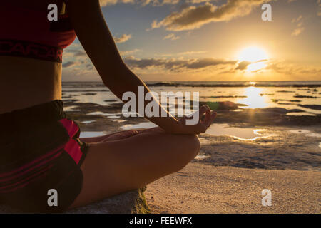 Frau praktizieren Yoga am Strand bei Sonnenaufgang, Fakarava, Tuamotu-Inseln, Französisch-Polynesien Stockfoto