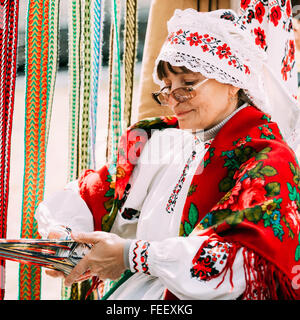 Gomel, Weißrussland - 12. September 2015: Frau in nationalen belarussischen Tracht weben Riemen Stockfoto