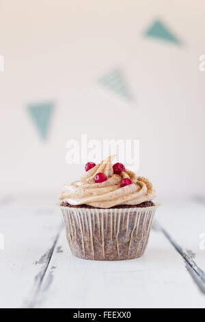 Geburtstag Cupcake eine weiße Holz- Hintergrund und eine Geburt tag Streamer Stockfoto