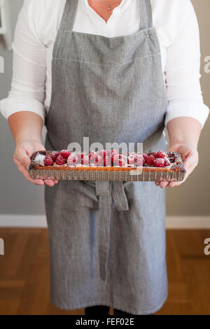 Frau mit einer Himbeer Torte Stockfoto