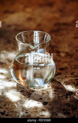 Transparente Kanne mit zwei Liter frisches Wasser mit Sonnenlicht. Gesunde Lebensweise. Selektiven Fokus. Stockfoto