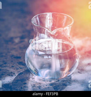 Transparente Kanne mit zwei Liter frisches Wasser mit Sonnenlicht. Gesunde Lebensweise. Selektiven Fokus. Bild mit getönten Stockfoto