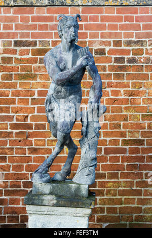 Schwenken Sie die Statue vor eine Mauer in Painswick Rokoko Gardens. Cotswolds, Gloucestershire, UK Stockfoto