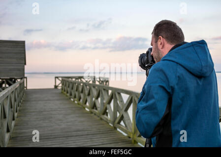 Professionellen Fotografen fotografieren Landschaft am See bei Sonnenuntergang Stockfoto