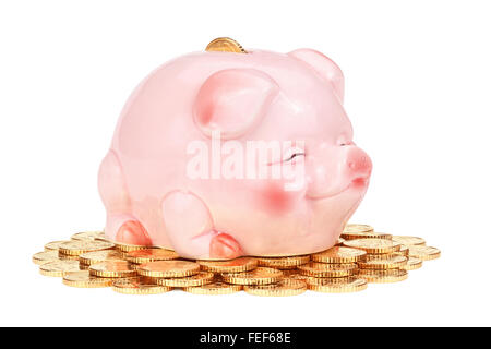 Rosa Sparschwein auf Haufen von Münzen, isoliert auf weißem Hintergrund, Clipping-Pfad enthalten. Stockfoto
