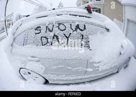 Merrick, New York, USA. 5. Februar 2016. Die Meldung SNOW DAY! ist im Schnee auf Auto-Tür-Fenster am Tag, an dem Hunderte von Schulen auf Long Island wegen Schneefall geschlossen sind, die am Vorabend begonnen gekritzelt. Eine teleskopierbare Schnee Bürste mit roten Eiskratzer ist am Dach des Auto in der Auffahrt des Hauses. Winter-Sturmwarnungen läuft für Nassau County am 13:00, und ein Durchschnitt von ungefähr 6 Zoll dürfte für den Bereich. © Ann Parry/ZUMA Draht/Alamy Live-Nachrichten Stockfoto