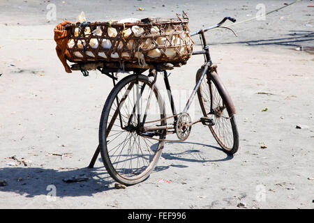 Alten rostigen Fahrrad mit einem Korb am Strand. Zanzibar Stockfoto