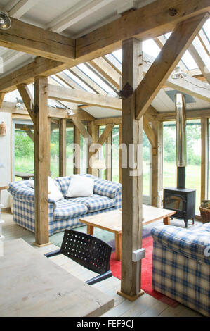 Eiche Struktur, Traversen, voll verglasten Türen und Fenster, Wohnzimmer mit Holzverbrennung Herd. Architekt entwarf Neubau. Stockfoto