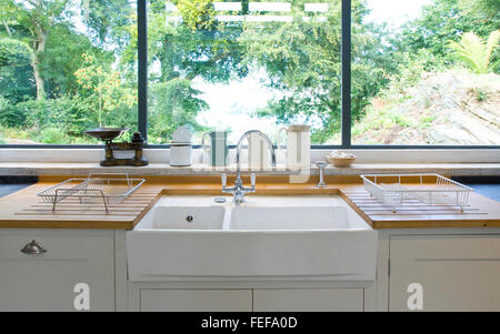 Neue weiße Küche, Großaufnahme der Küchenspüle mit Blick aus Fenster. Stockfoto