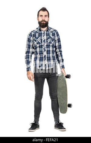 Hipster mit Skateboard, Blick in die Kamera. Ganzkörper-Länge-Porträt über weiße Studio-Hintergrund isoliert. Stockfoto