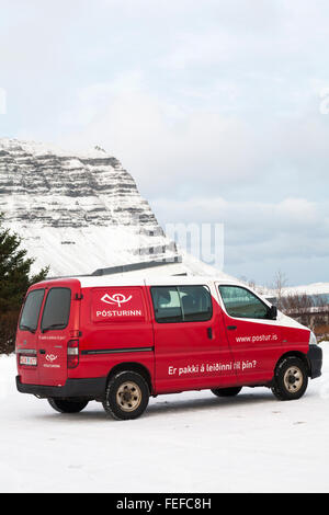 Posturinn post Van mit Schnee bedeckte Berge hinter in Island im Februar Stockfoto