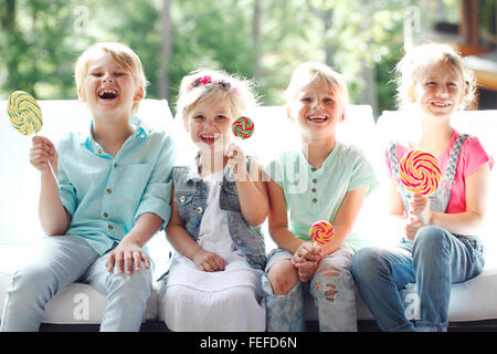 Gruppe von glücklich lächelnden Kindern mit Lutscher im freien Stockfoto