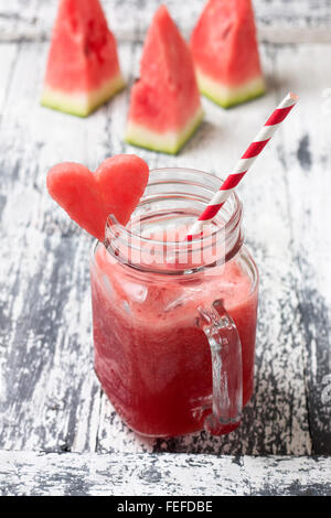 frische Wassermelone Smoothie in ein Einmachglas, Scheiben Wassermelone auf einem hölzernen Hintergrund Stockfoto