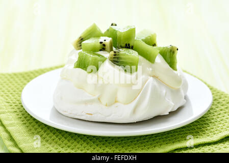 Pavlova Kuchen mit Kiwi-Scheiben und Schlagsahne Stockfoto