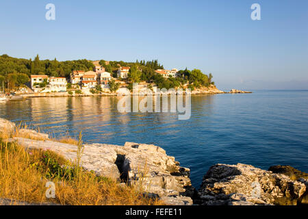 Kassiopi, Korfu, Ionische Inseln, Griechenland. Felsigen Landzunge von der frühen Morgensonne beleuchtet. Stockfoto