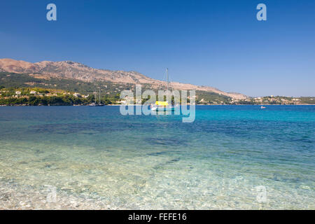 Kassiopi, Korfu, Ionische Inseln, Griechenland. Blick über das klare türkisfarbene Wasser des Avlaki Bay Yacht vor der Küste verankert. Stockfoto